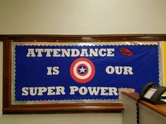 a sign that says attendance is our super power on the wall next to a phone