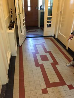 a man standing in front of a door on top of a tiled floor next to a doorway