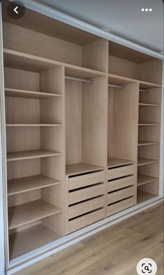 an empty closet with wooden shelves and drawers