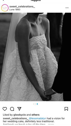 a black and white photo of a woman in a wedding dress holding the hand of a man