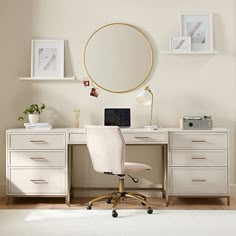 a white desk with a chair and a round mirror on the wall in front of it