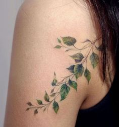 a woman's shoulder with green leaves on the back of her neck and arm