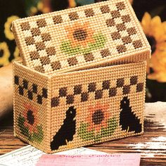 a basket with birds and flowers on it sitting on a table next to some papers