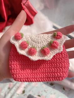 a crocheted purse is being held in someone's hand