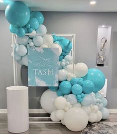 balloons and streamers are on display in a room with a sign that says happy birthday tash