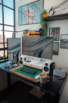 a computer desk with two monitors and speakers