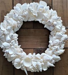 a wreath made out of seashells on a wooden wall