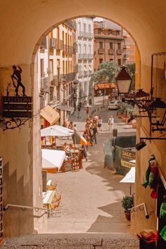 an archway leads to the street where vendors are selling their goods