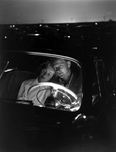 an old photo of two people in a car