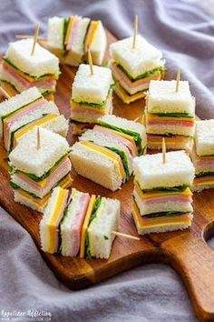 mini sandwiches are arranged on a cutting board