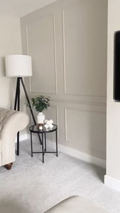 a living room with a couch, table and television on the wall next to it