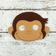 a felt monkey mask is shown on a white wooden surface with the words little gray's stitching