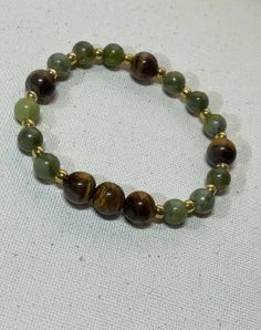 This beautiful handmade bracelet was made with Green aventurine tiger eye quartz beads.  It's the perfect accessory for any occasion whether casual or elegant  Measure are : 6mm  Fits most wrist sizes and has some gentle flexible give to put on and take off easily. Green And Brown Bracelets, Green Beaded Bracelets, Bracelets Ideas, Brown Bracelet, Quartz Beads, Hazel Eyes, Eye Bracelet, Handmade Bracelet, Green Bead