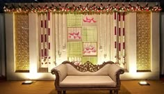 a white couch sitting in front of a window covered in curtains and string lights with butterflies on them