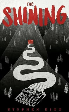 the shining book cover with an old typewriter and trees in the background on top of a mountain