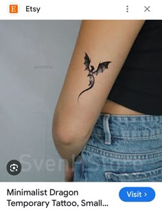 a small dragon tattoo on the left side of the arm, with an arrow in the middle