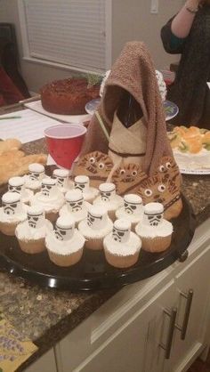 a table topped with cupcakes covered in frosting next to a stuffed animal