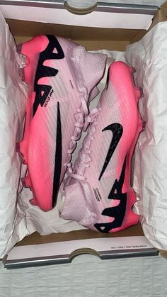 a pair of pink nike shoes in a box