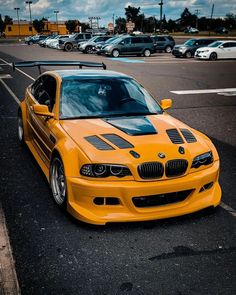 a yellow bmw is parked on the side of the road