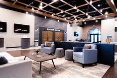 an office lobby with couches, chairs and tables in front of a bar area