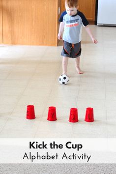 a young boy kicking a soccer ball around red cones with the words kick the cup alphabet activity