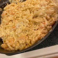 a skillet filled with macaroni and cheese on top of a stovetop