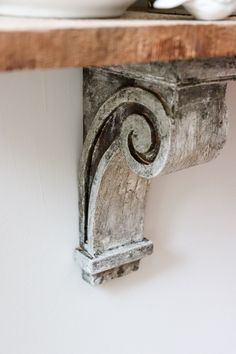 a white bowl sitting on top of a wooden shelf