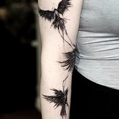 a woman's arm with three black flowers on the left side of her arm