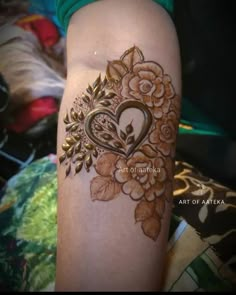 a woman's arm with a tattoo on it that is decorated with flowers and leaves