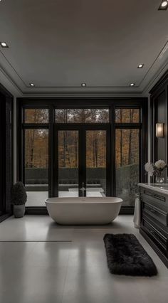 an elegant bathroom with large windows and a freestanding bathtub in the middle of the room