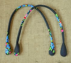 three colorful braided ties laying on top of a piece of cloth next to each other