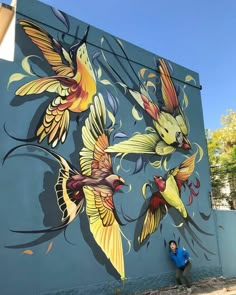 a woman is standing in front of a painted mural on the side of a building