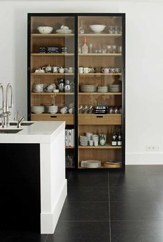 an open cabinet in the middle of a kitchen