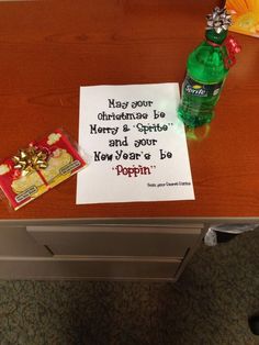 a table with a note, candy and a bottle of soda sitting on top of it