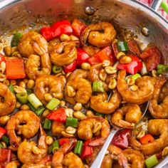 shrimp and vegetable stir fry in a pan with tongs