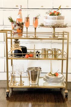 a gold bar cart filled with drinks and glasses