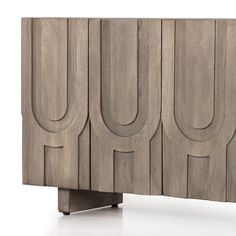 the sideboard is made out of wood and has an interesting carving pattern on it