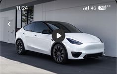 a white tesla model x parked in front of a building with an arrow pointing to the left