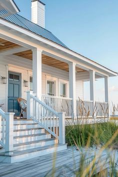 a white house with porch and stairs leading to the front door