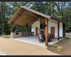 a covered outdoor kitchen with grill and seating area in the middle of an open lot