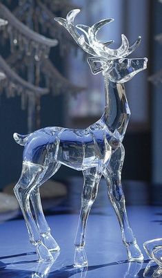 a crystal deer figurine on a blue surface