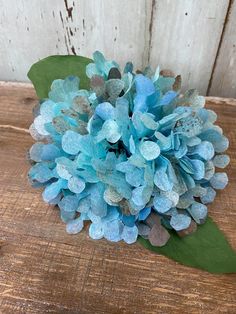 a blue flower sitting on top of a wooden table