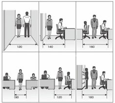 people are standing in an office setting and sitting at desks with their hands on the chairs