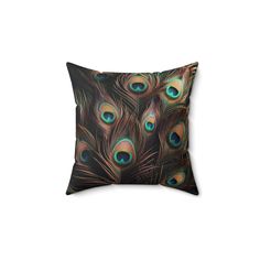 a decorative pillow with peacock feathers on the front and back, it has a black background