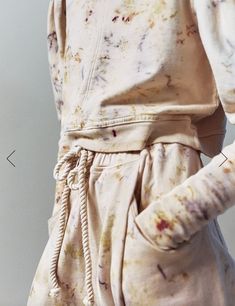 a person wearing a white shirt and pants with paint splattered all over it