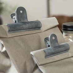 two pieces of fabric with metal clips on them sitting on top of a wooden table