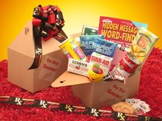 an open box filled with snacks on top of a red carpet next to a ribbon