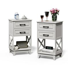 two white nightstands with flowers and wine glasses on each side, one has an alarm clock