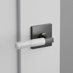 a door handle with a white stick sticking out of it's center hole on a gray wall