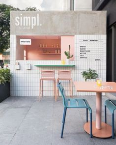 an outdoor cafe with tables, chairs and planters on the outside wall that says simple